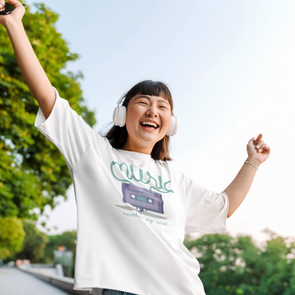 girl enjoying music wearing a oversized tshirt with retro graphic and text "music soothese my soul"