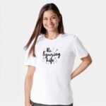 smiling woman wearing white tshirt printed motivatonal quote re figuring life